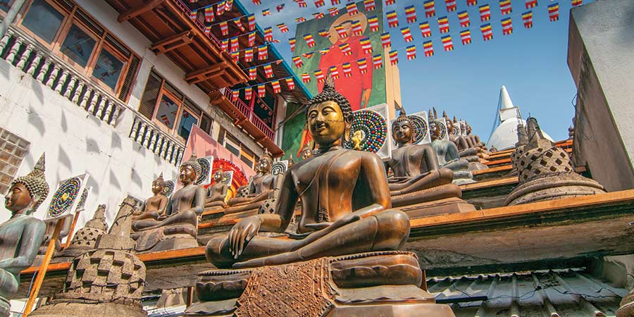 A buddhist temple with many Buddha statues and colourful decorations